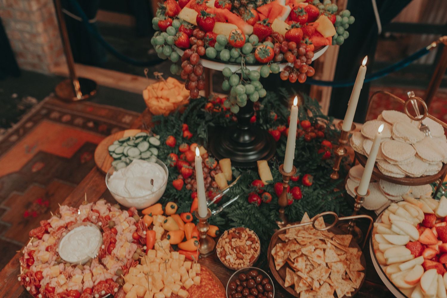 Beautifully decorated dessert table with red floral accents and tiered displays.