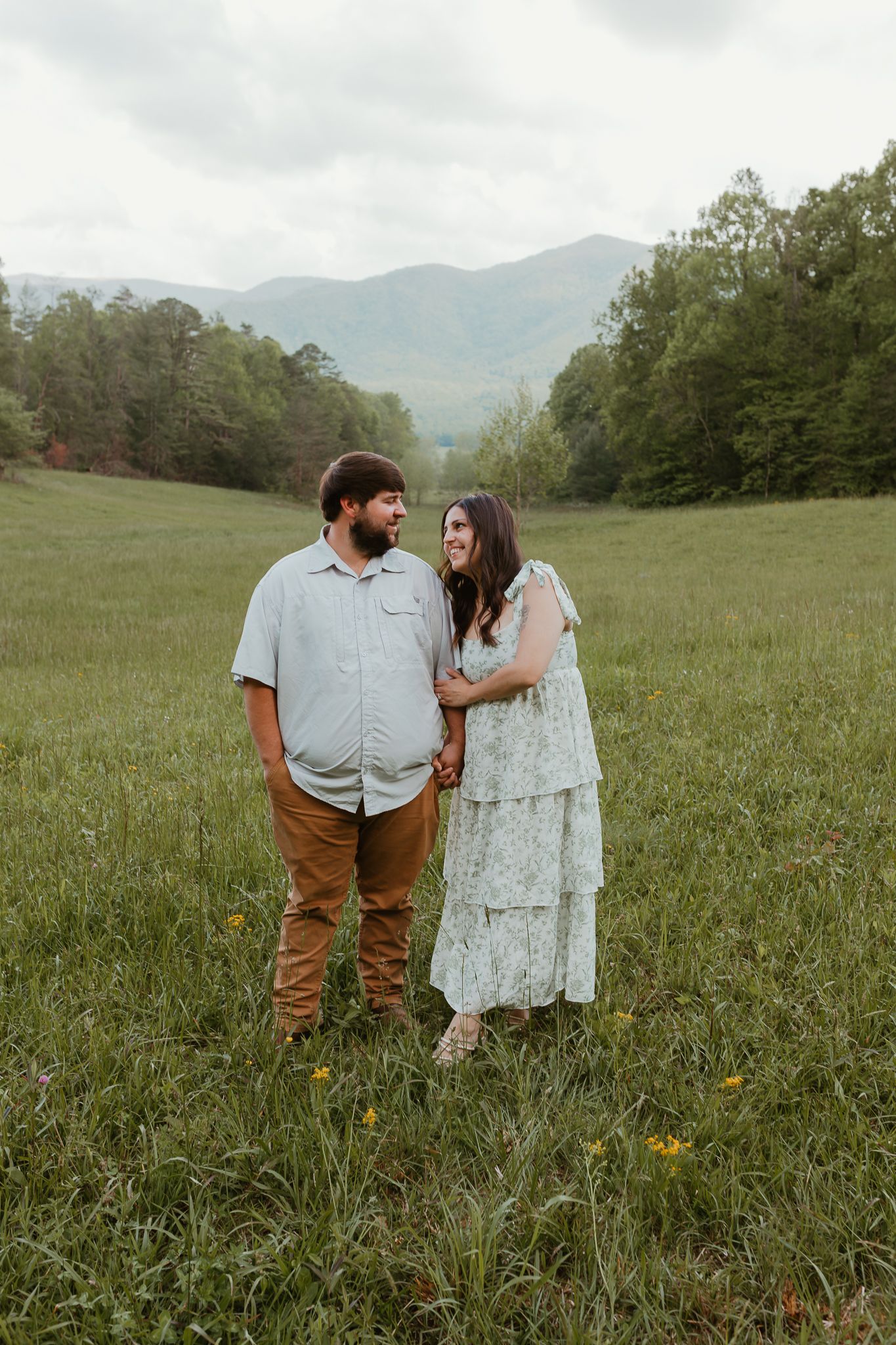 Couple sharing intimate moments in a mountain meadow with wildflowers.