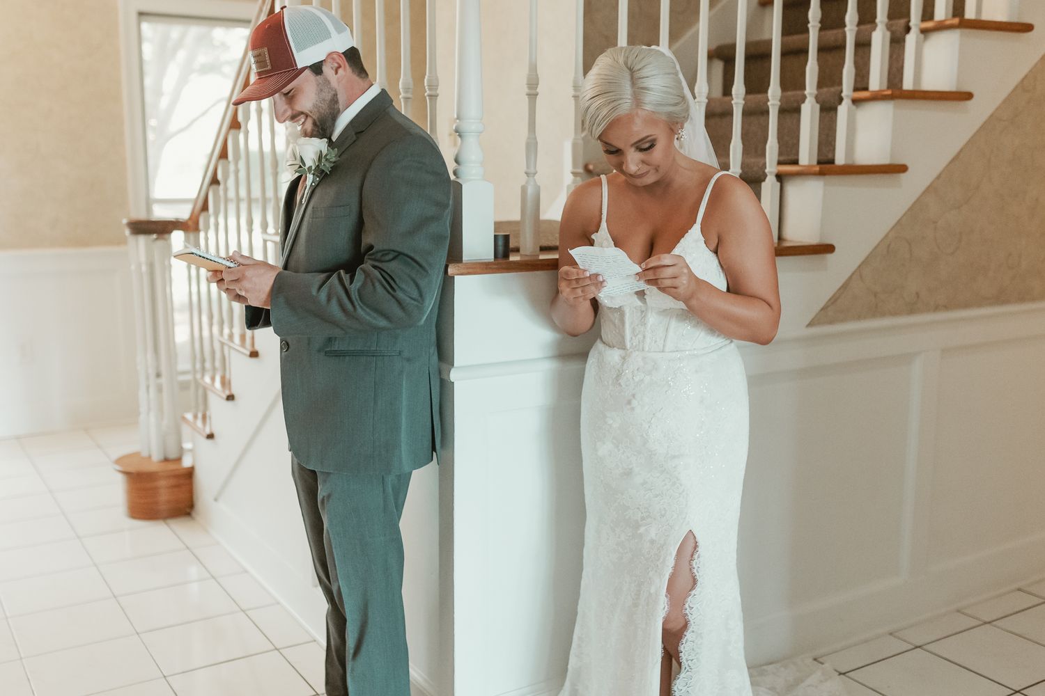 Couple exchanging letters before wedding ceremony in bright indoor setting.