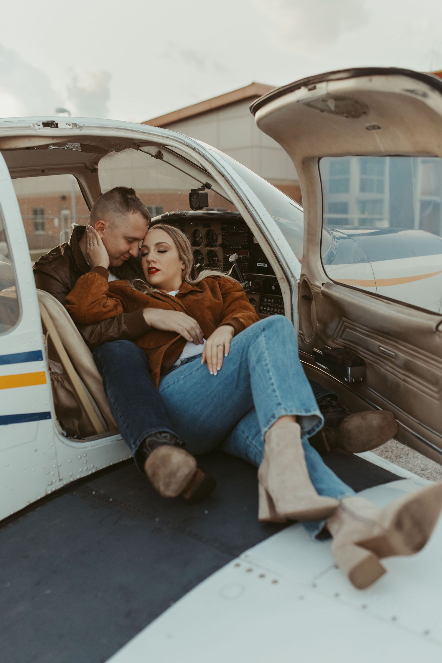 A couple shares an intimate moment inside a small aircraft cabin.