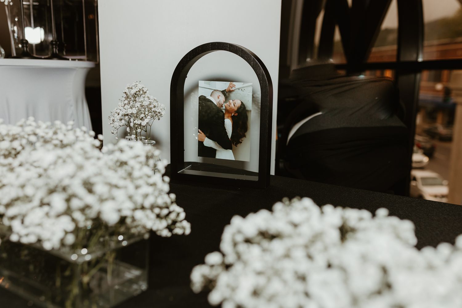 Delicate baby's breath flowers arranged as wedding decor against a dark background.