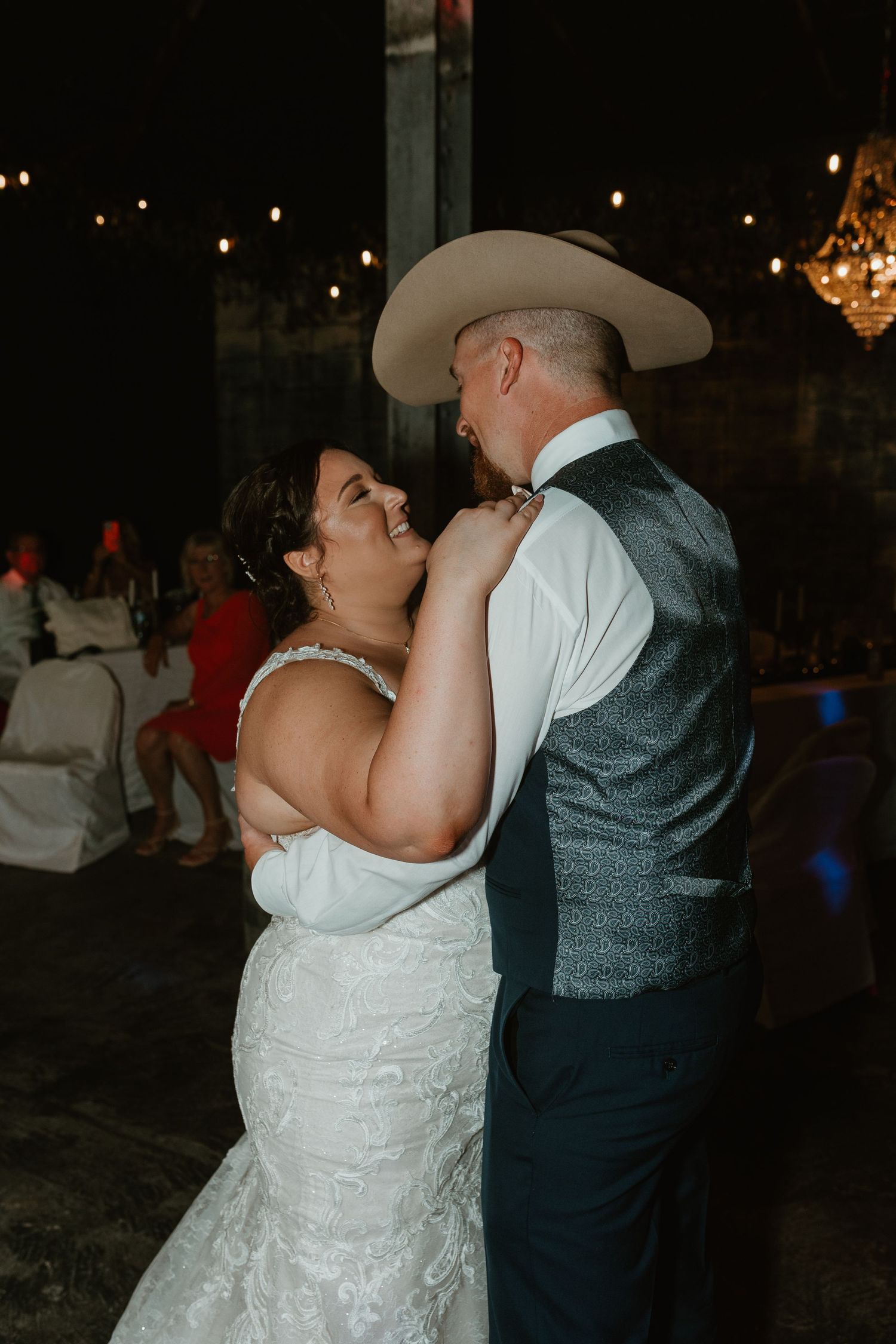 A couple shares their first dance at a dimly lit wedding reception with string lights overhead. Chattanooga Wedding Photographer