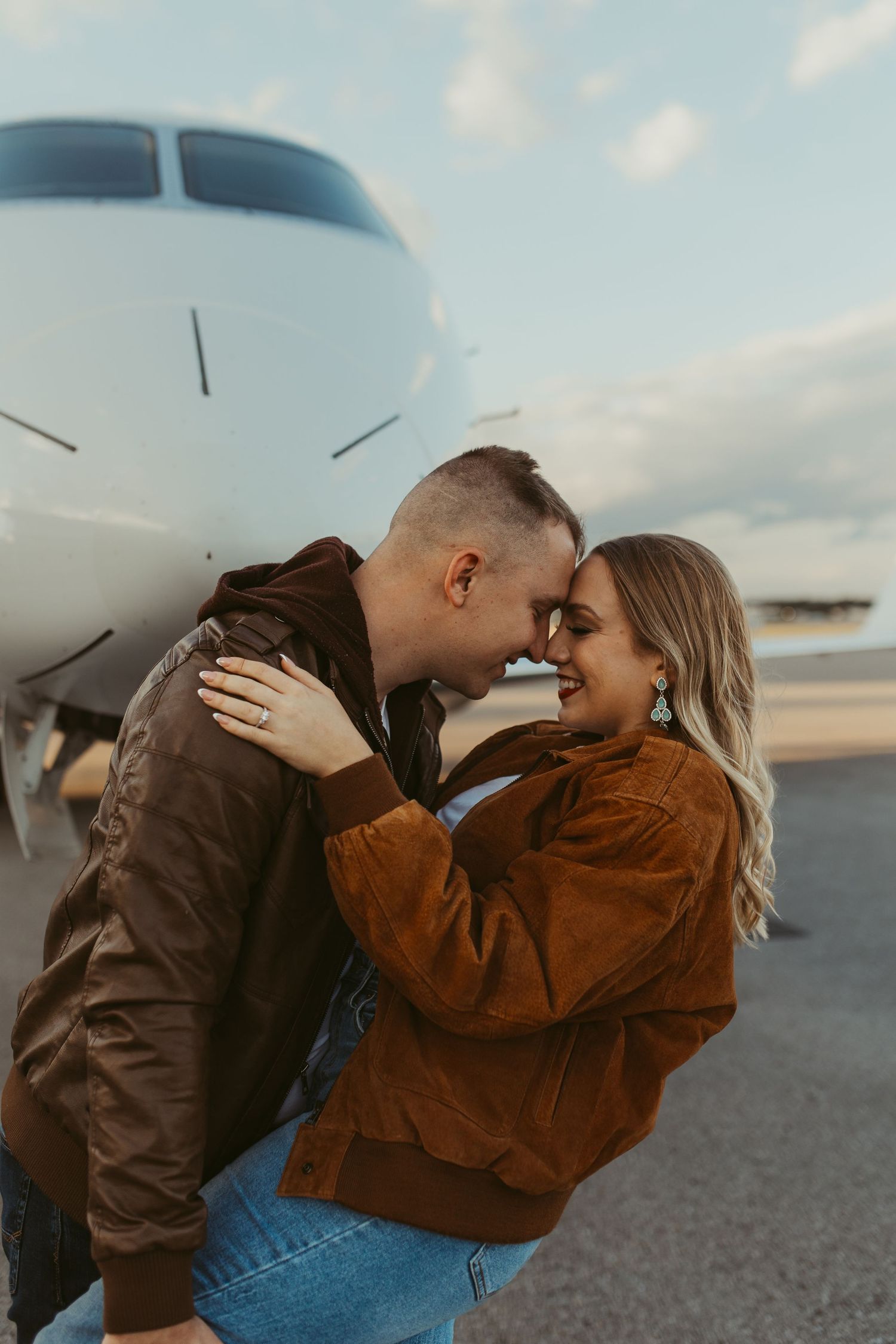 Romantic aviation themed couple photos against aircraft at golden hour.