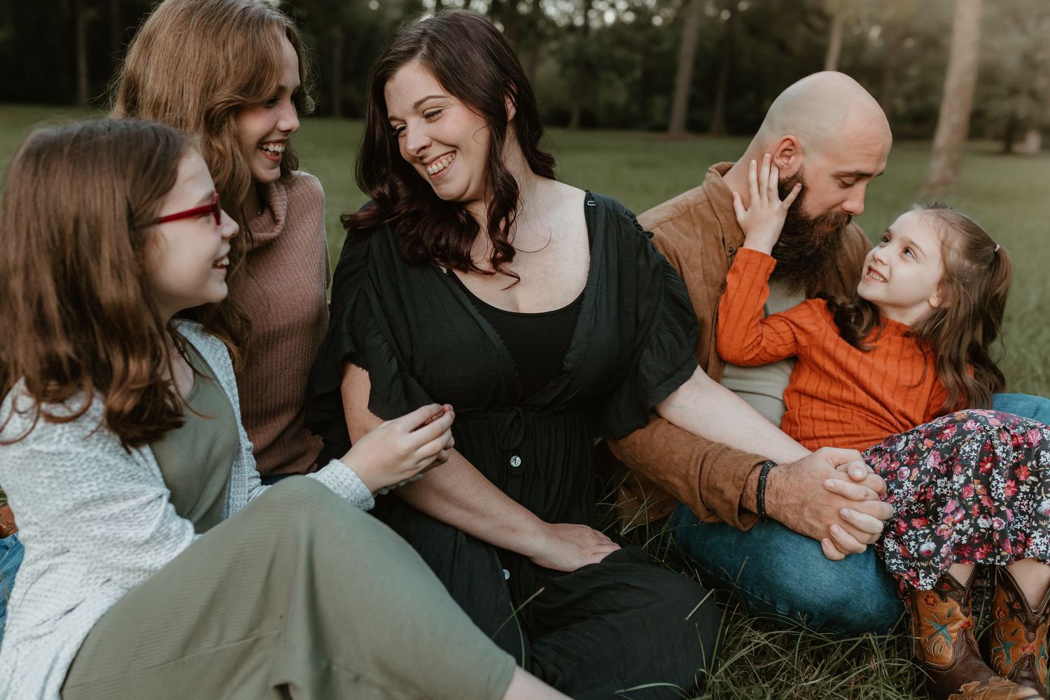 Casual family gathering on grass showing genuine laughter and connection.