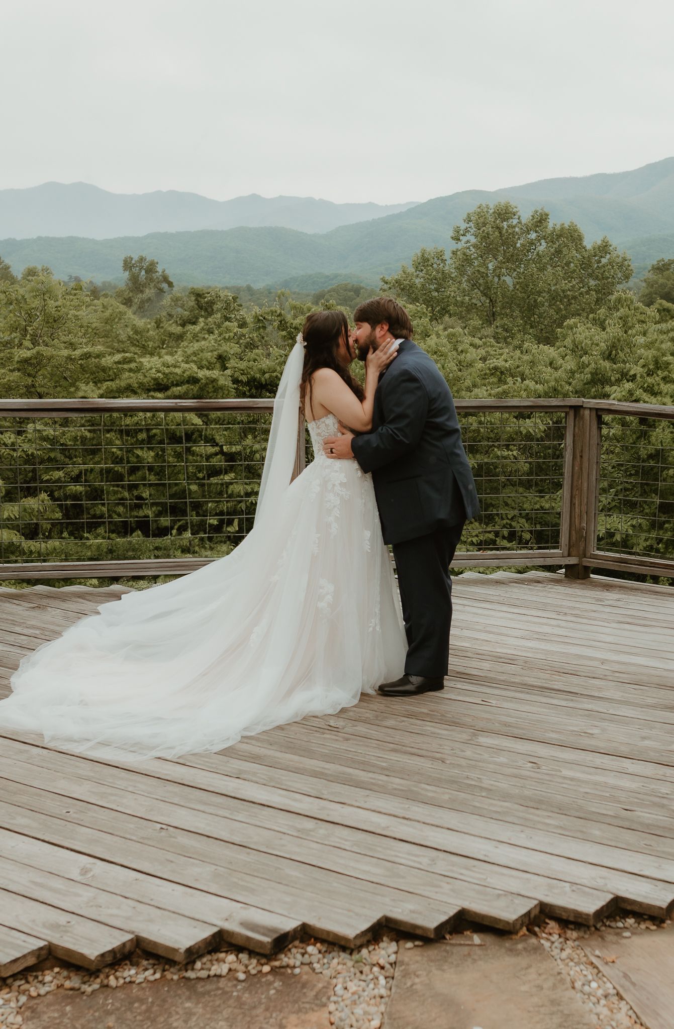 Romantic wedding photos on a wooden deck overlooking mountain views.