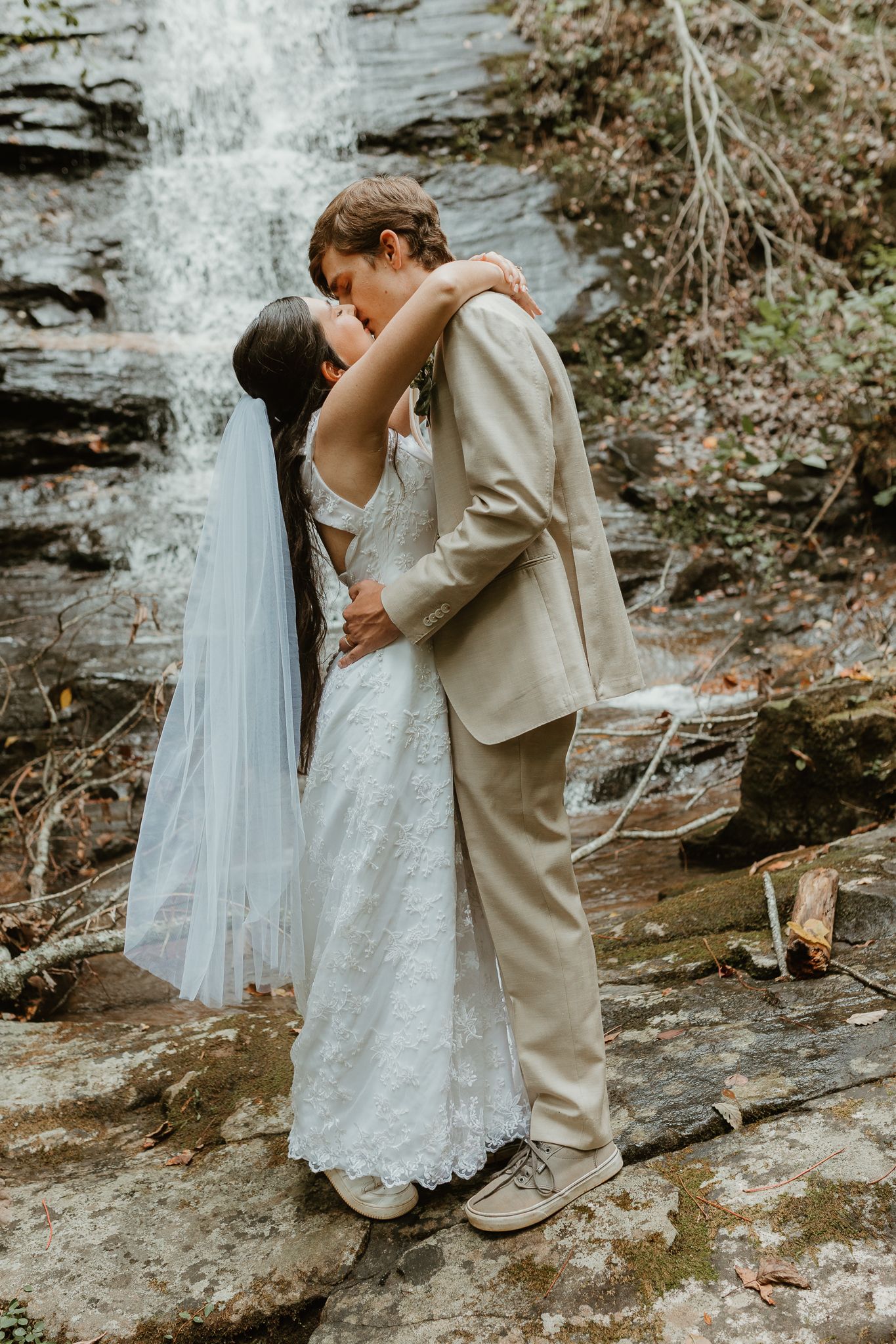 A romantic wedding portrait in front of a cascading waterfall.