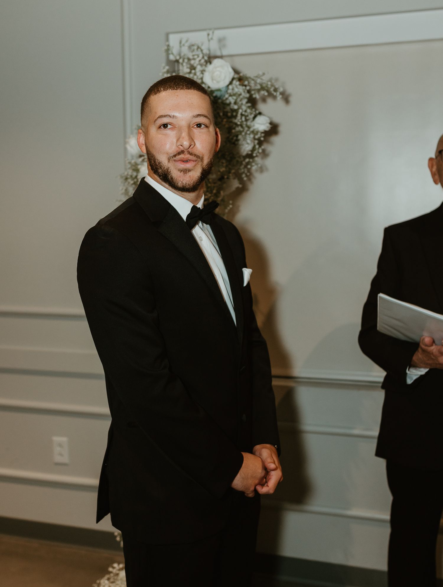 Wedding ceremony in a modern white venue with elegant decor.