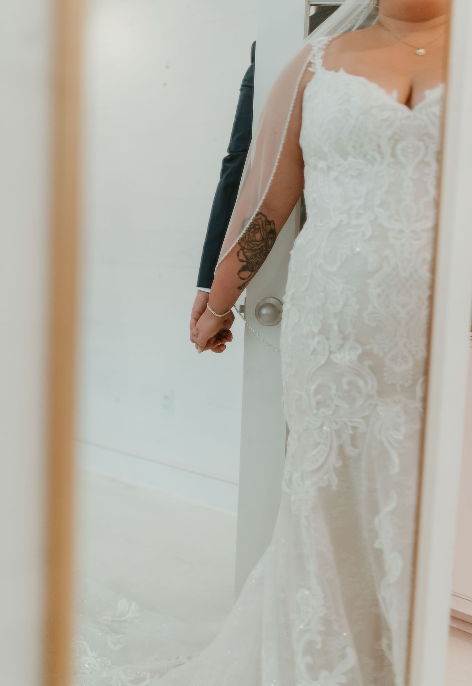 Close-up detail of a fitted lace wedding gown showing intricate patterns and design.