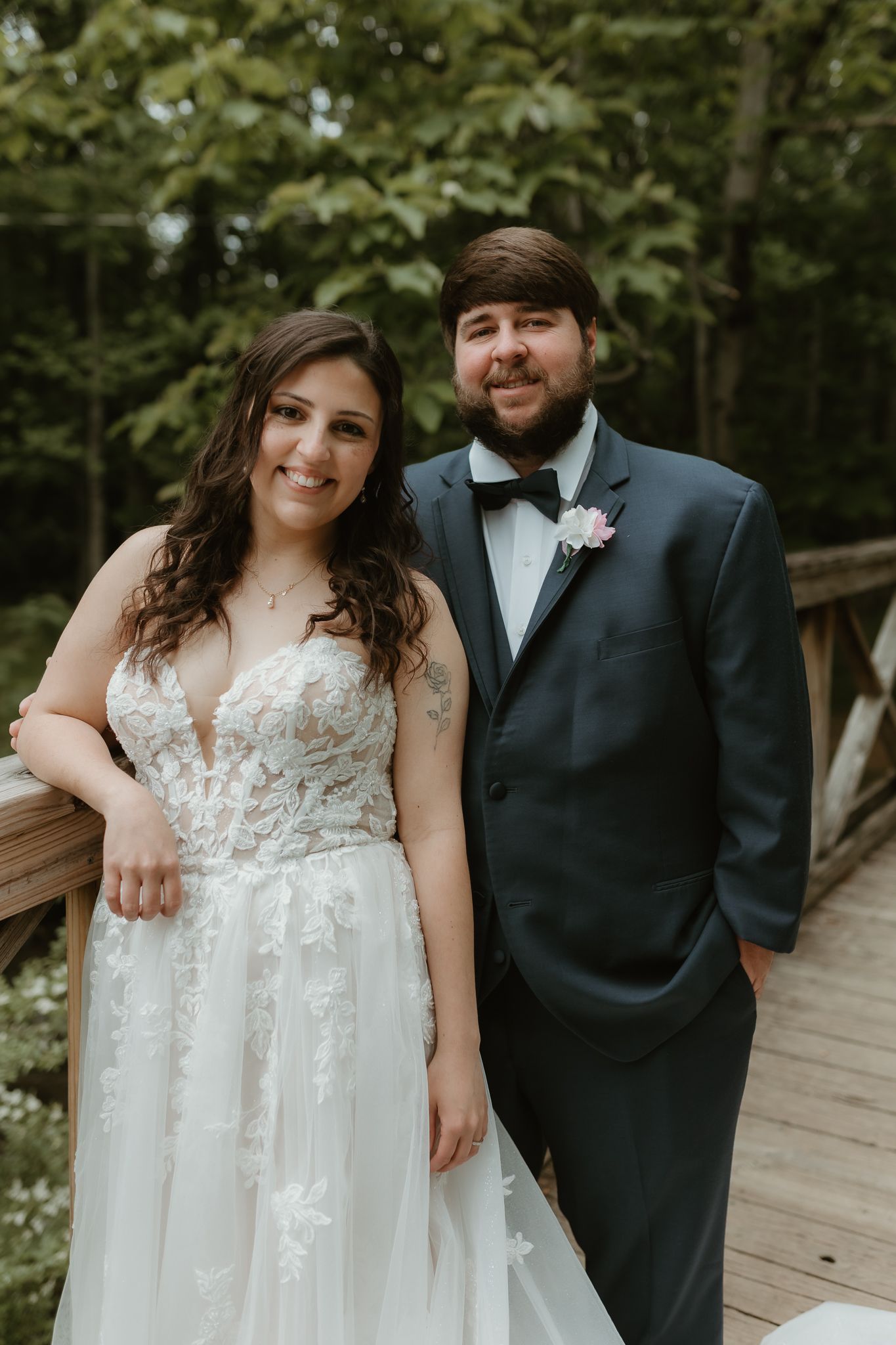 Wedding couple shares intimate moment on rustic wooden bridge walkway.