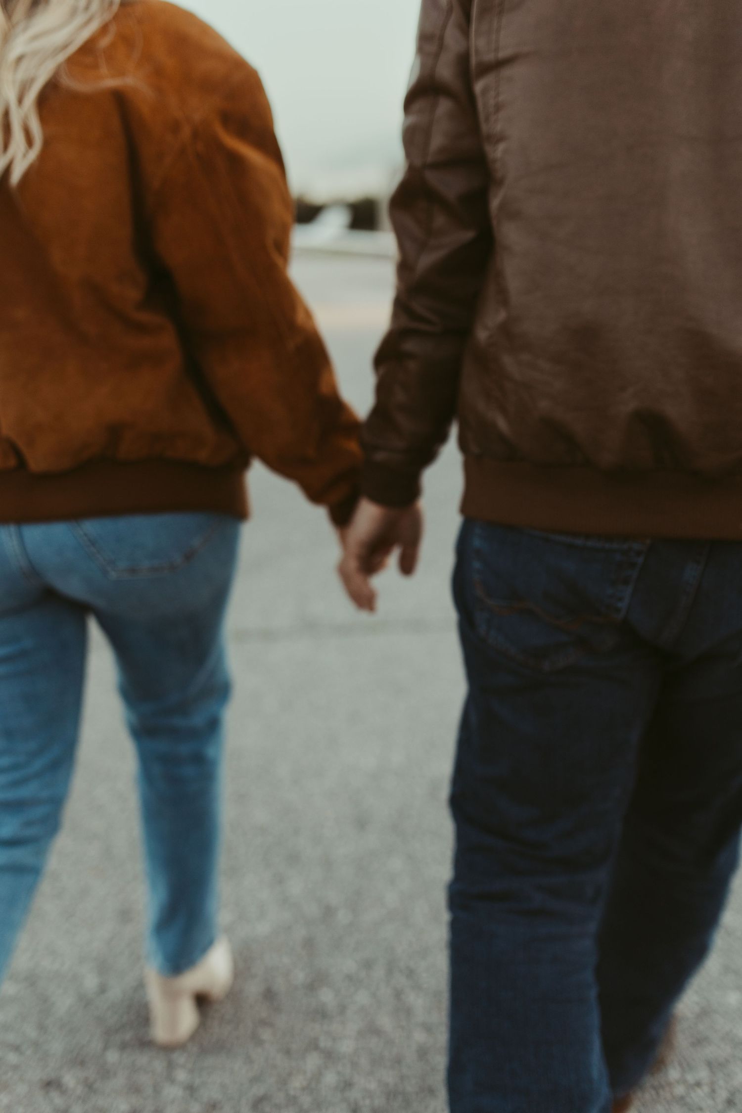 Close-up view of two people in casual attire walking together on an airport tarmac.