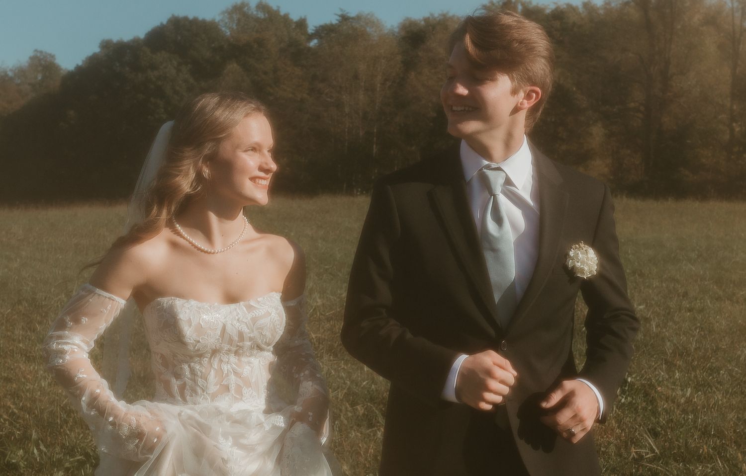 Joyful newlyweds sharing a romantic moment in an autumn field.