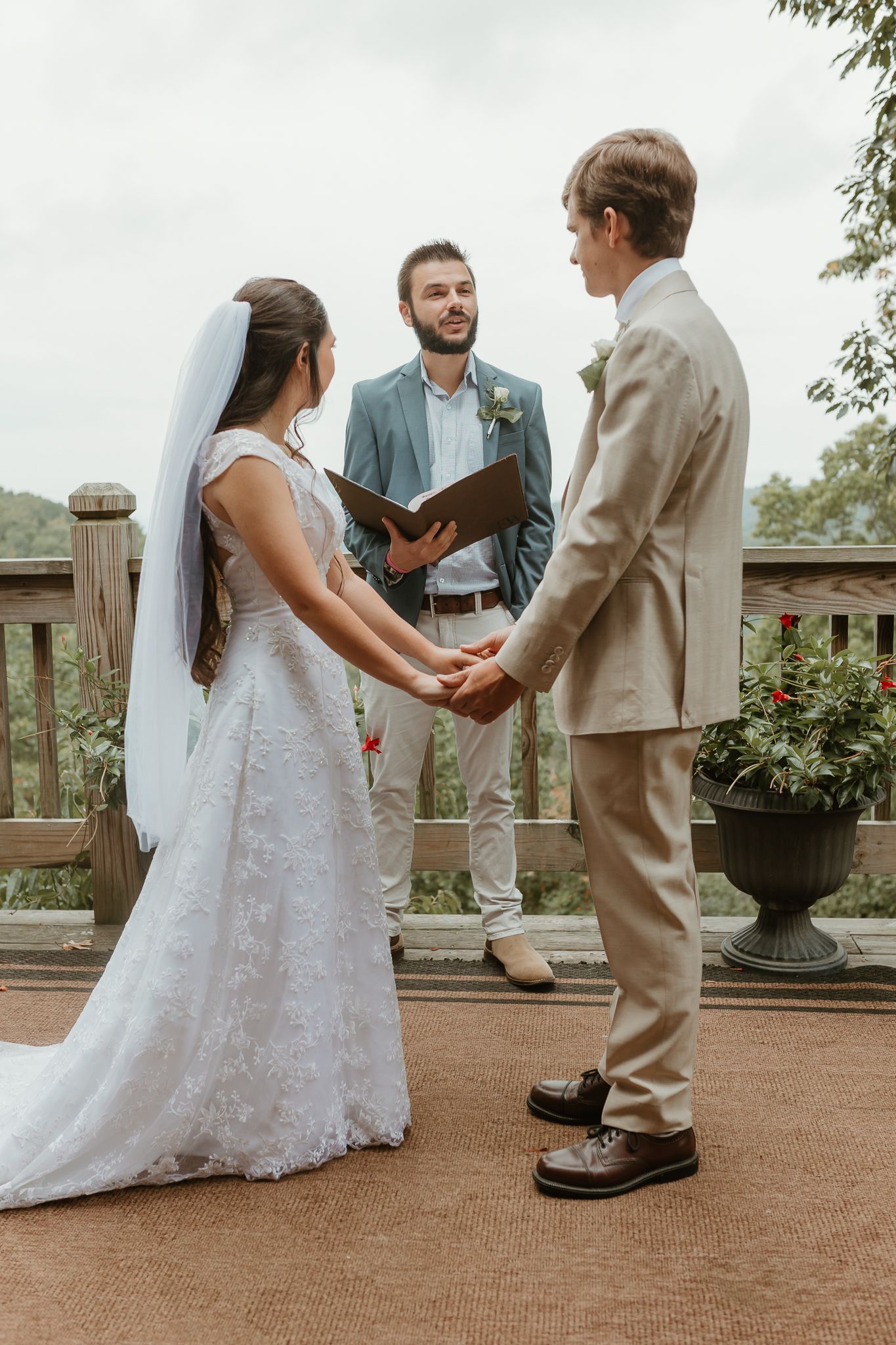 An outdoor wedding ceremony on a deck overlooking scenic mountain views.