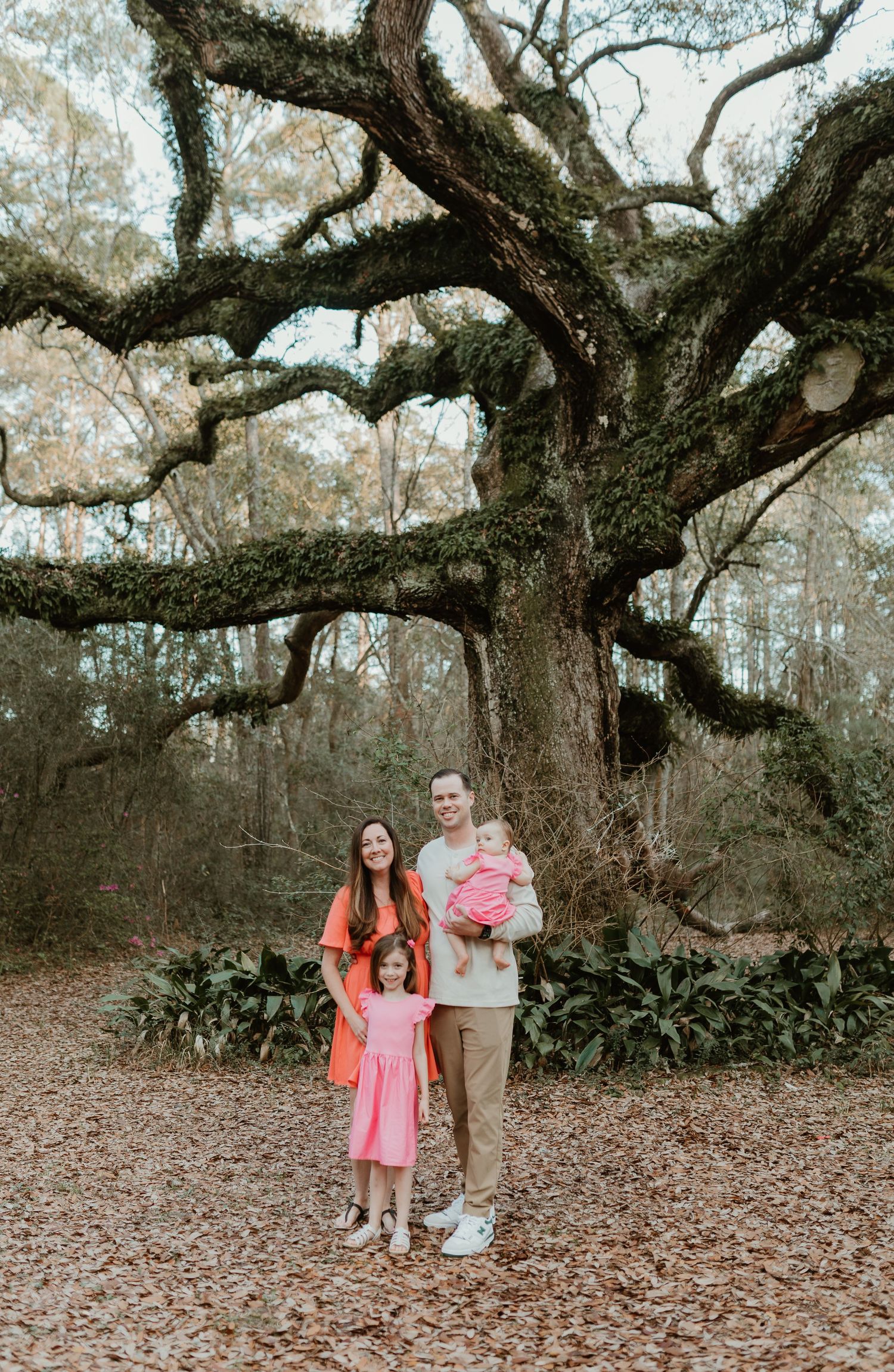 Family portrait session under a majestic oak tree with sprawling branches.