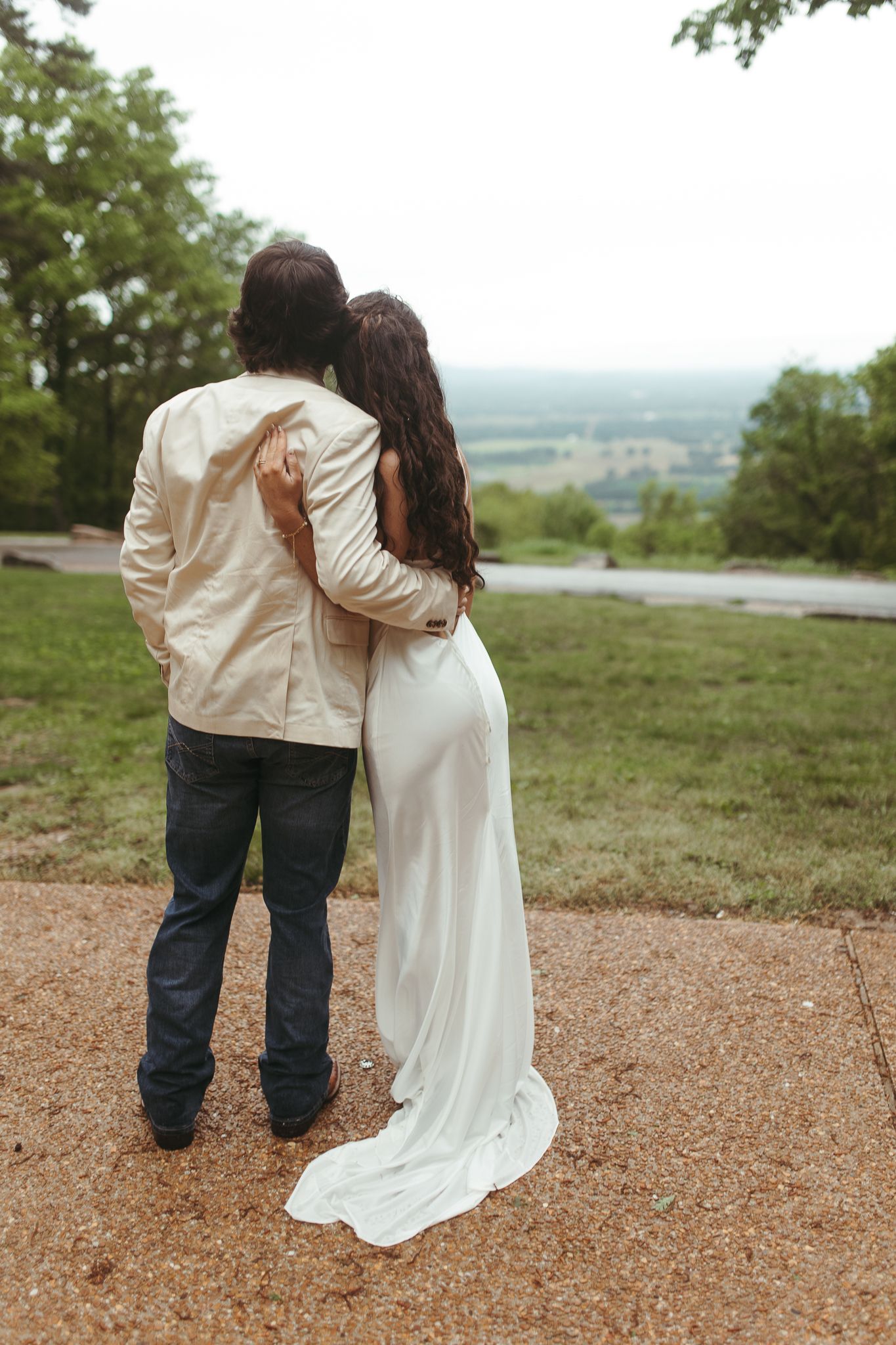 A couple shares an intimate moment while overlooking a scenic mountain vista.