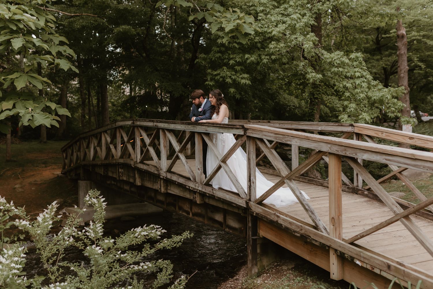 Long wooden footbridge creates perfect backdrop for wedding photography.
