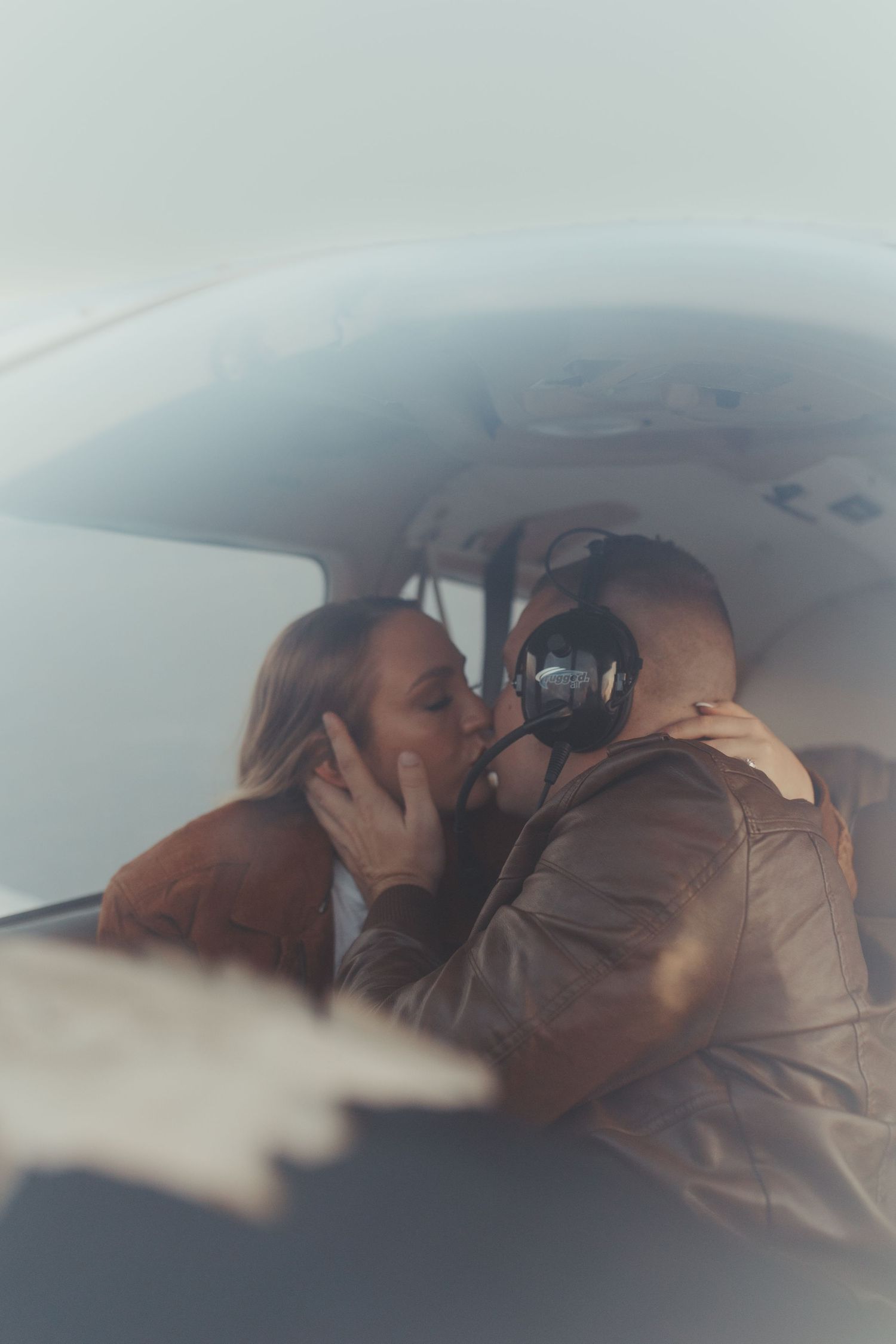 Interior view of a small aircraft cabin with two people sharing an intimate moment.