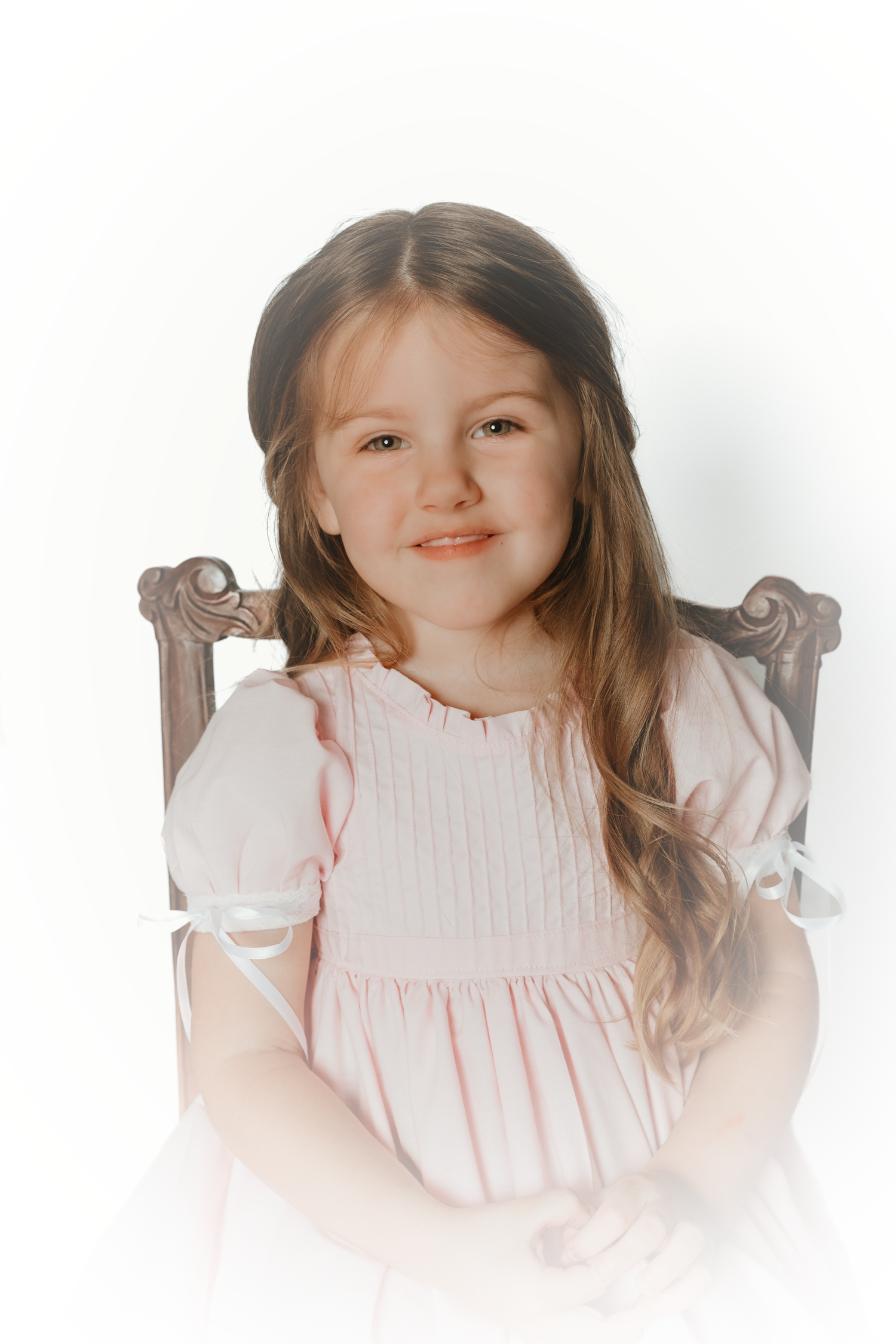 Three portraits of a young child wearing a pink smocked dress against white background.