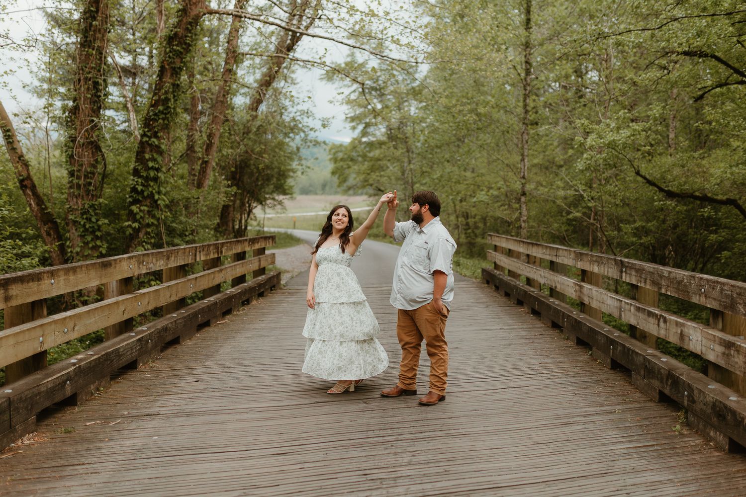 Series of photos showing a couple walking along a wooden bridge pathway in nature.