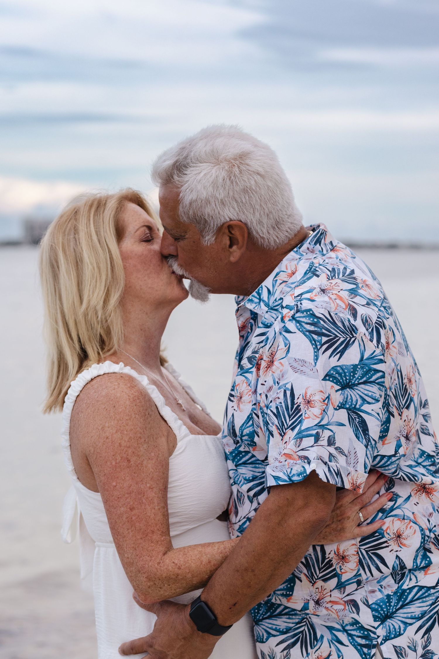Romantic couple kissing on the beach during a sunset photography session in North Palm Beach, Florida