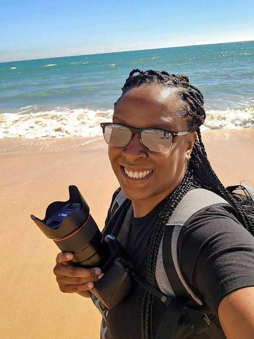 Friends taking beachside selfies together on a bright sunny day by the ocean.