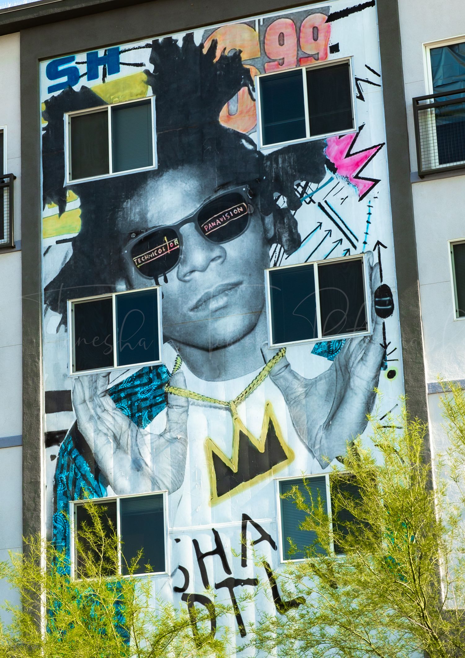 Urban street art mural featuring stylized portraits and graffiti elements on a building wall.
