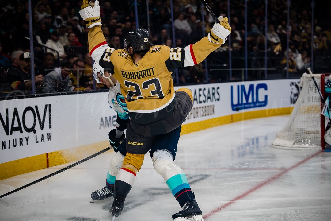 Hockey player in yellow jersey makes a diving save during an intense NHL game.