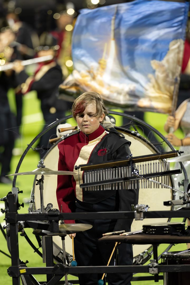 Musician playing a xylophone during a marching band performance.