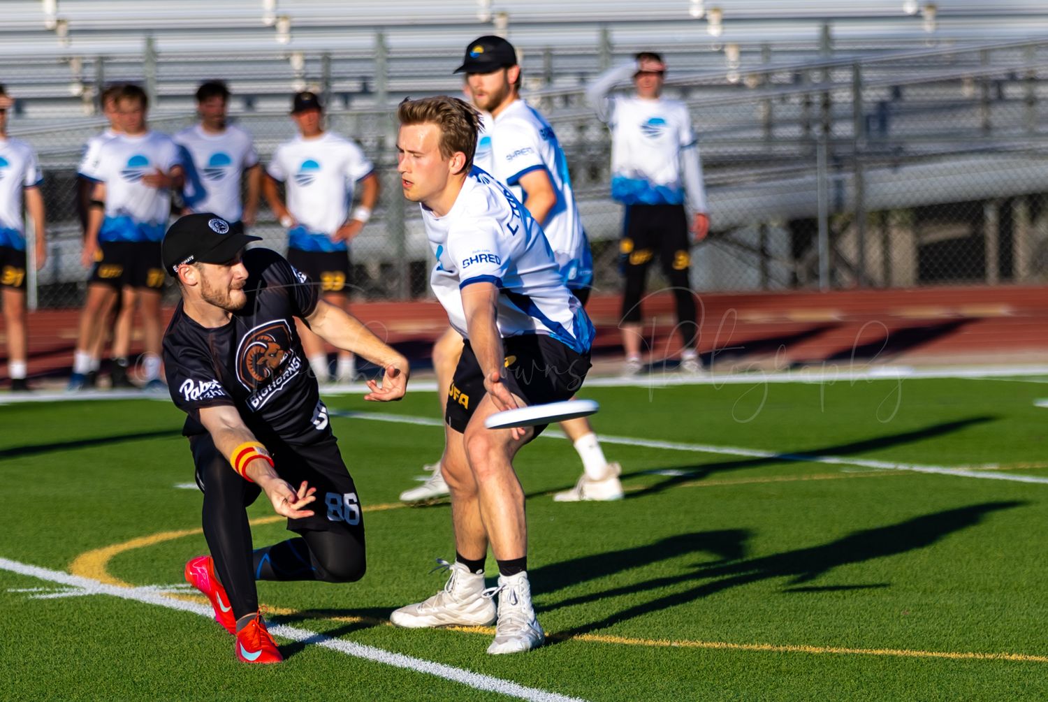 Athletes warming up and stretching on a sunny sports field.