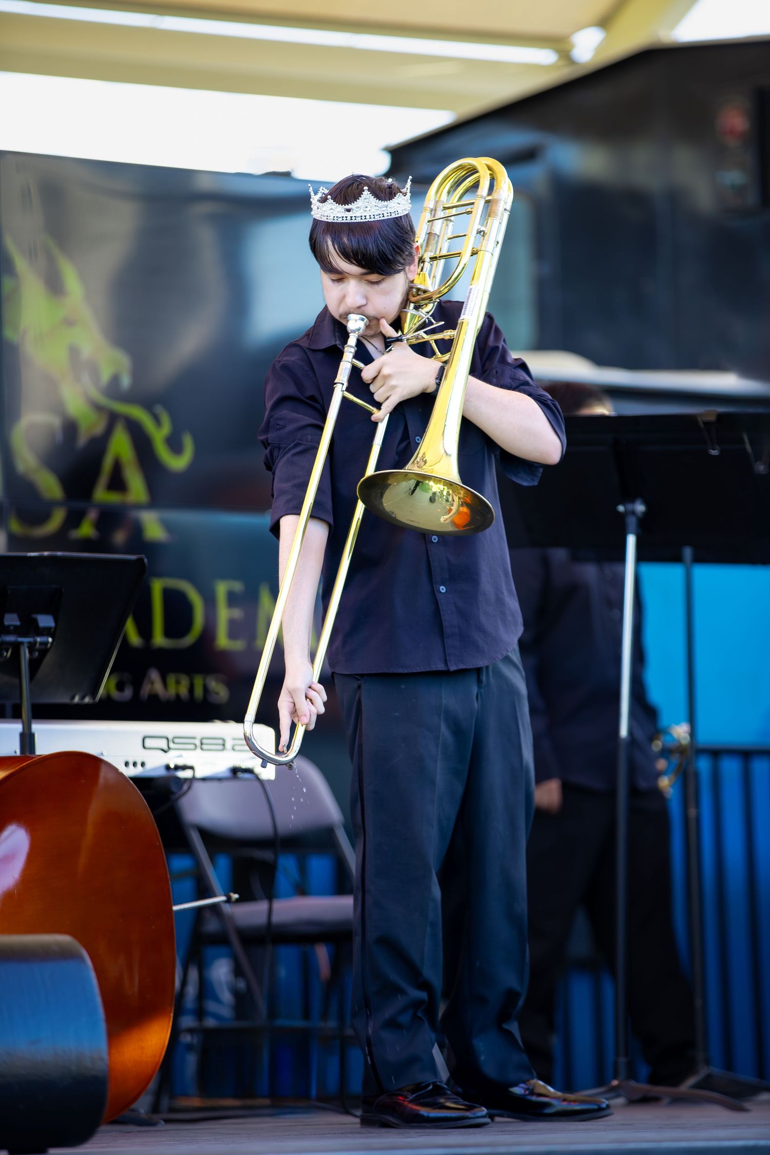 Musicians playing trombones during a performance on stage.