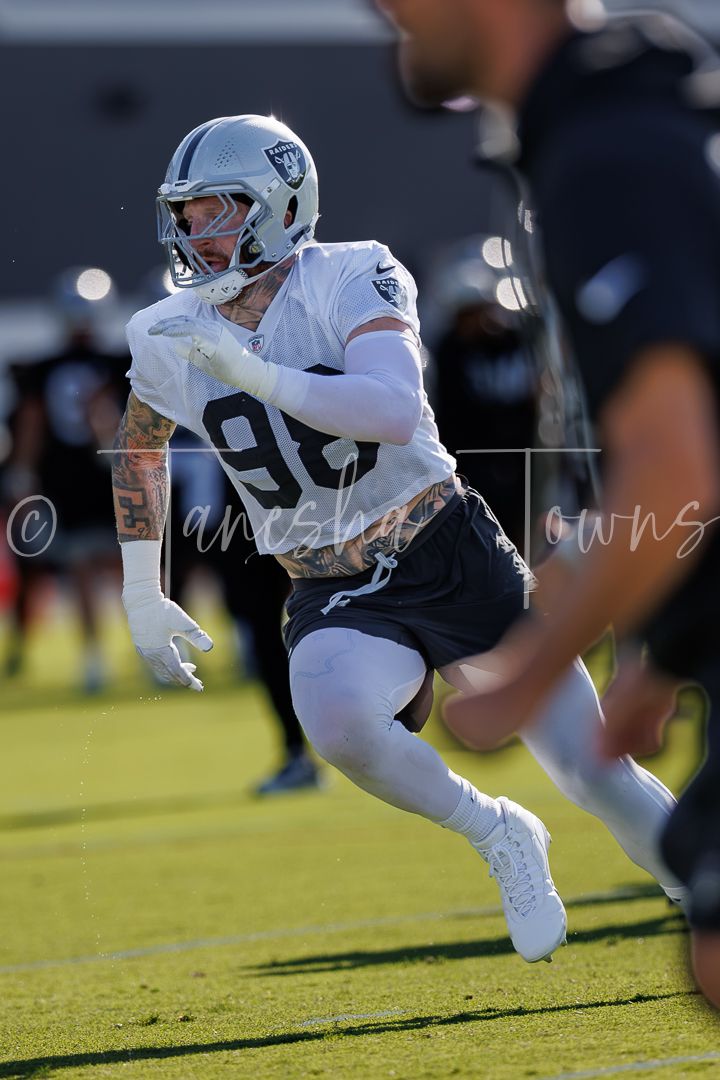 Las Vegas Raiders defensive player number 98 rushes during an NFL training camp drill.