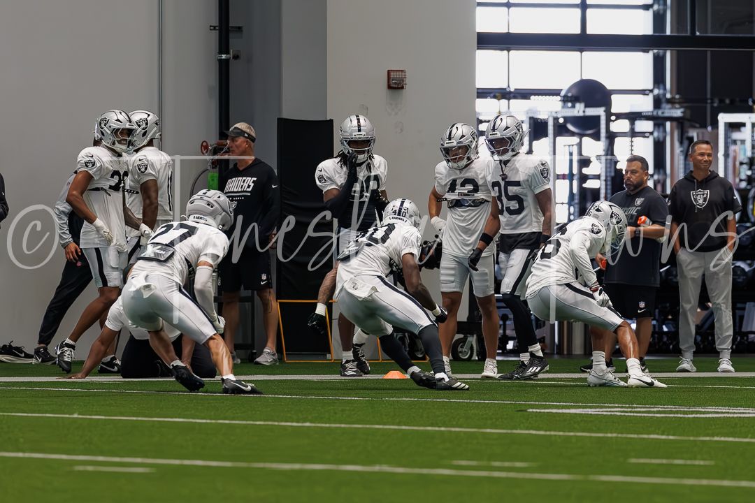 Las Vegas Raiders players run drills during indoor training camp practice.