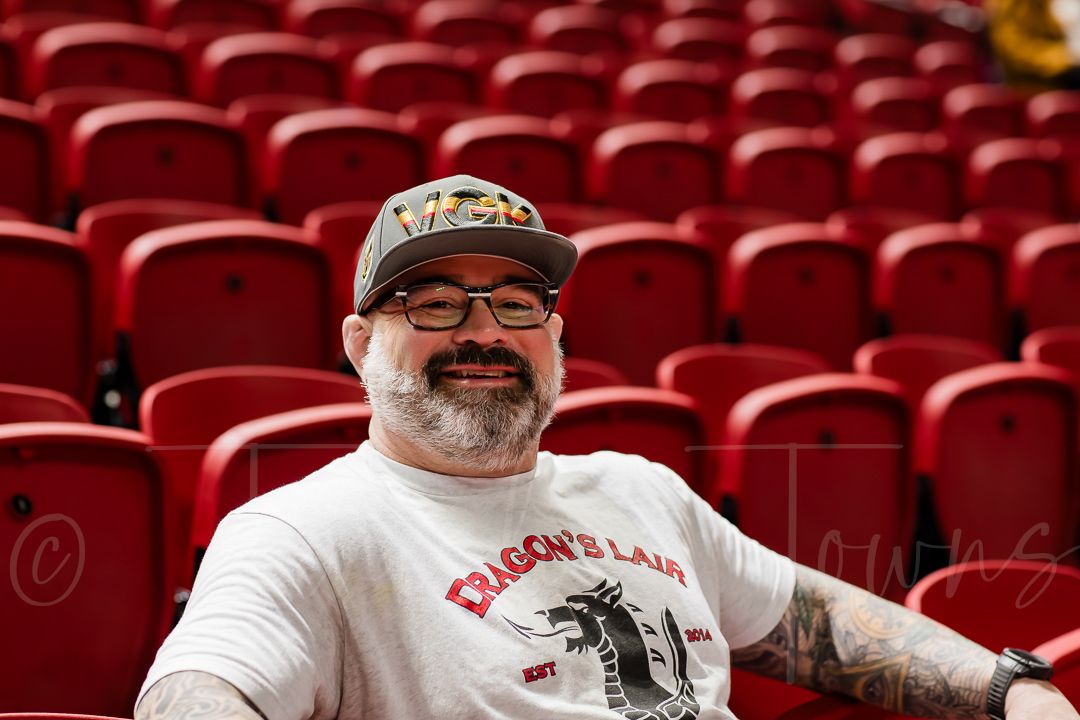 Row of empty red stadium seats in an indoor sports arena.