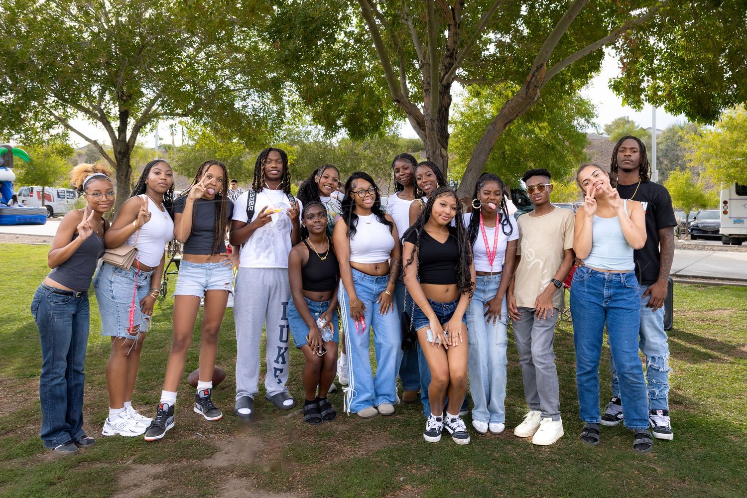 A large group of people pose together outdoors for a casual group photo.