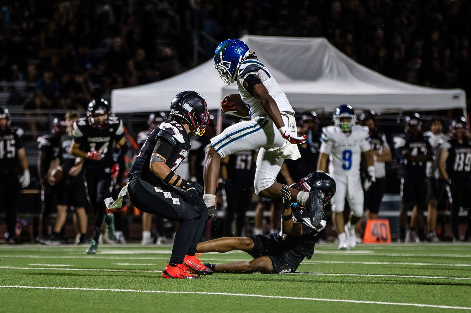 Football players diving for the ball during intense game action.