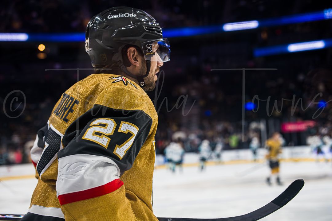 NHL players compete for possession during a fast-paced hockey match between Vegas and Seattle teams.