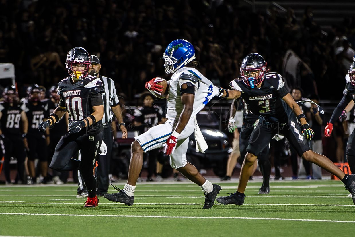 Football players diving and stretching during an intense game play sequence.