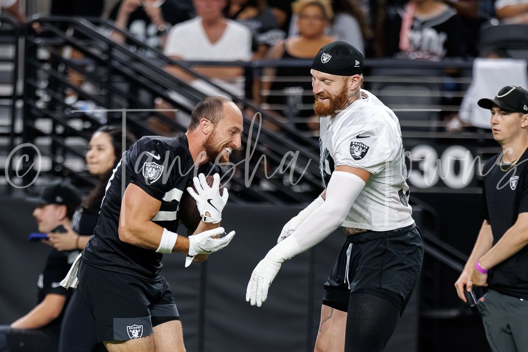 Two Las Vegas Raiders players practice drills on the field during training.