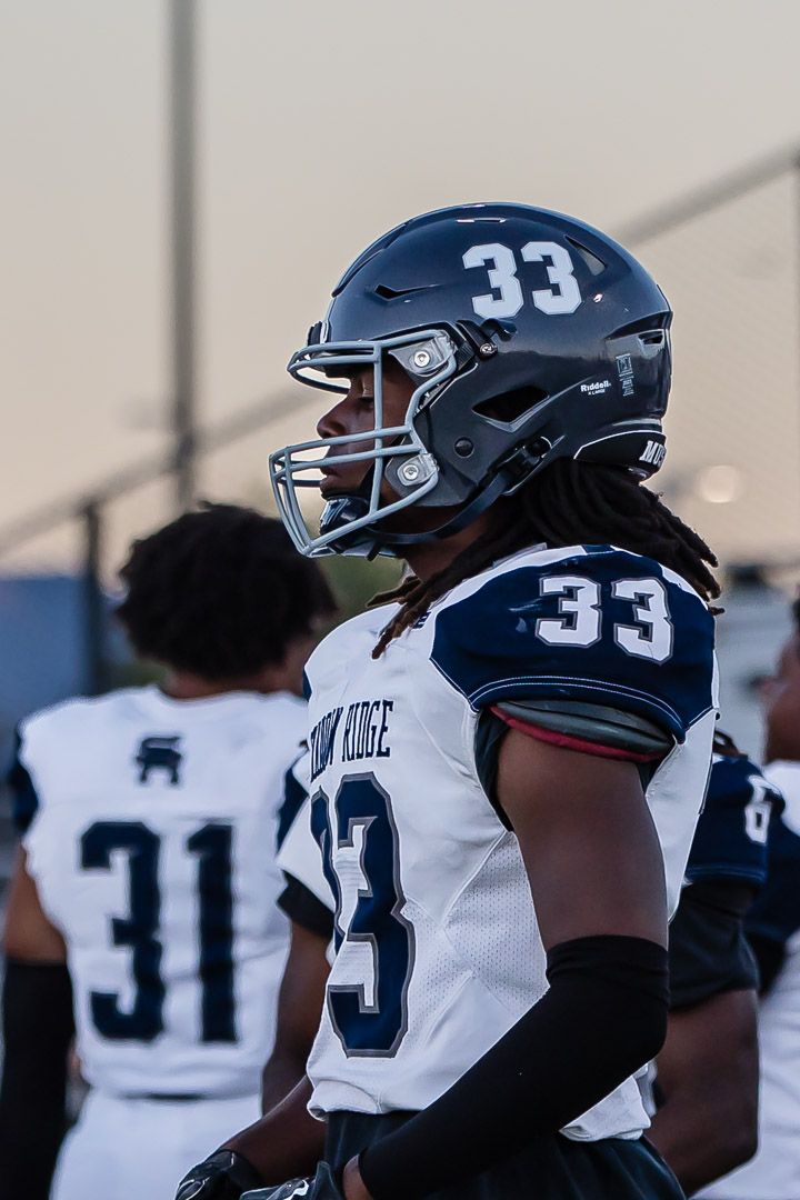 Shadow Ridge football player wearing number 33 white jersey during game.