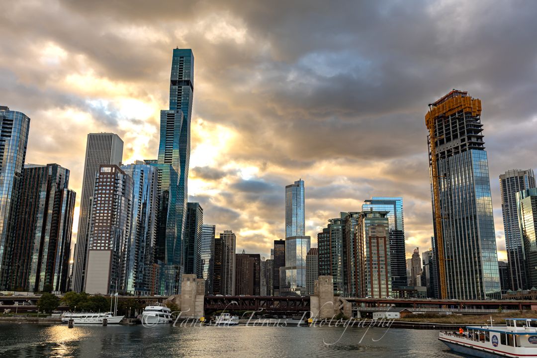 Modern skyscrapers of Chicago's downtown skyline reflect golden sunset light along the riverfront.