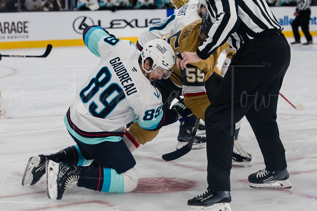 NHL hockey players battle for the puck during an intense game between the Seattle Kraken and Vegas Golden Knights.