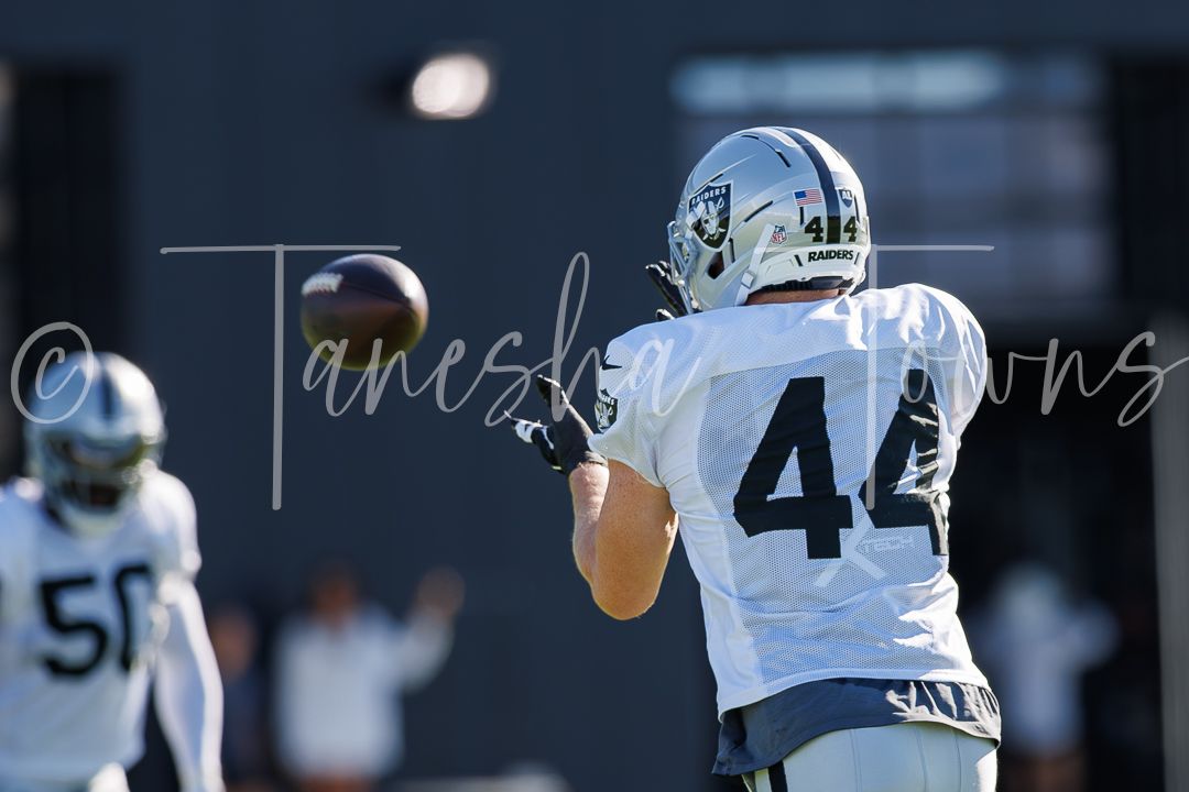Raiders player #44 catches a football during practice at training camp.