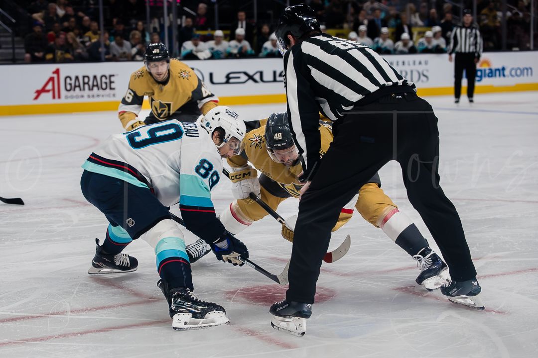 Professional hockey players battle for puck control during an intense game sequence.