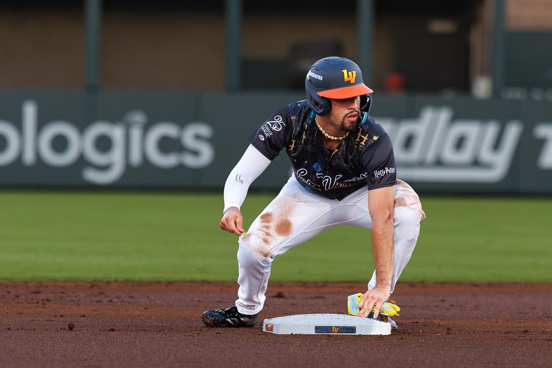 Las Vegas Aviators baserunner crouches low on second base in colorful uniform during minor league game.