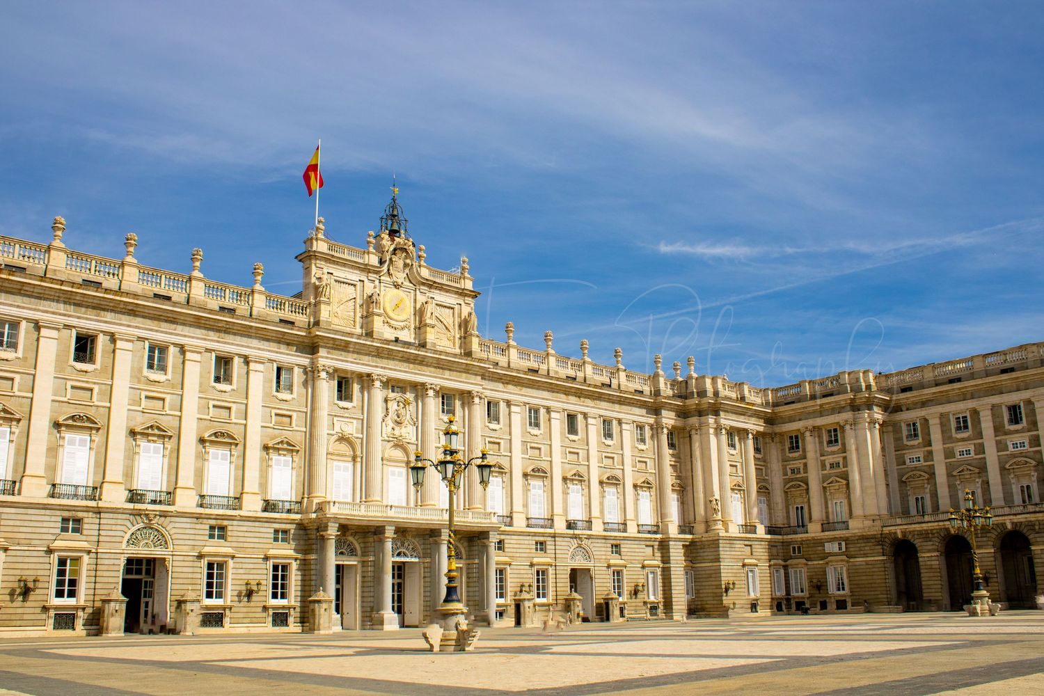 Grand palace facade with classical architecture under blue sky.