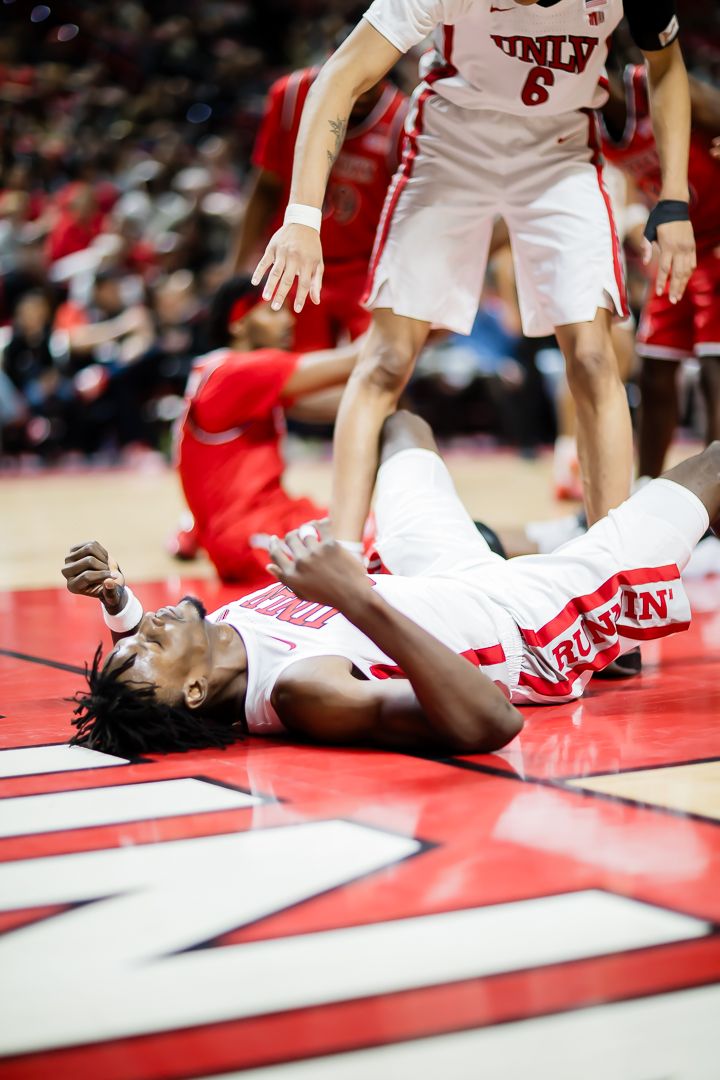 Basketball player falls to the ground during an intense game sequence shown in multiple action frames.