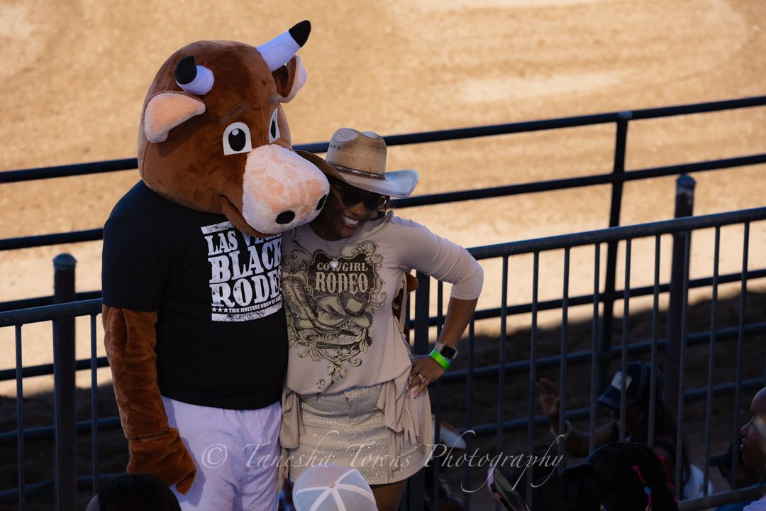 Bull rider competes in rodeo event at Las Vegas arena with spectators watching from stands.