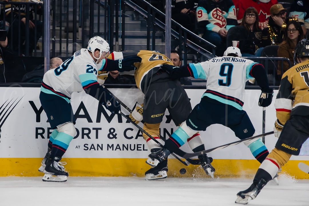 NHL players from opposing teams engage in a physical battle along the boards during gameplay.