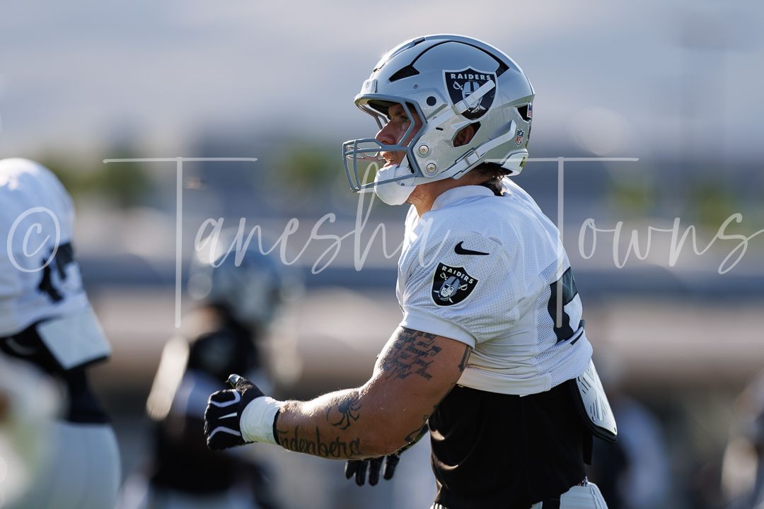 Las Vegas Raiders player in full gear during outdoor training camp practice.
