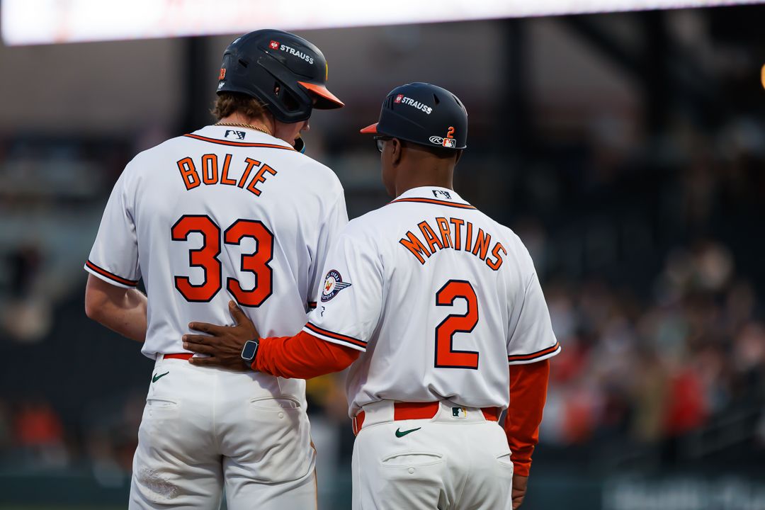 Baltimore Orioles players Bolte #33 and Martins #2 stand together on field in white away uniforms.