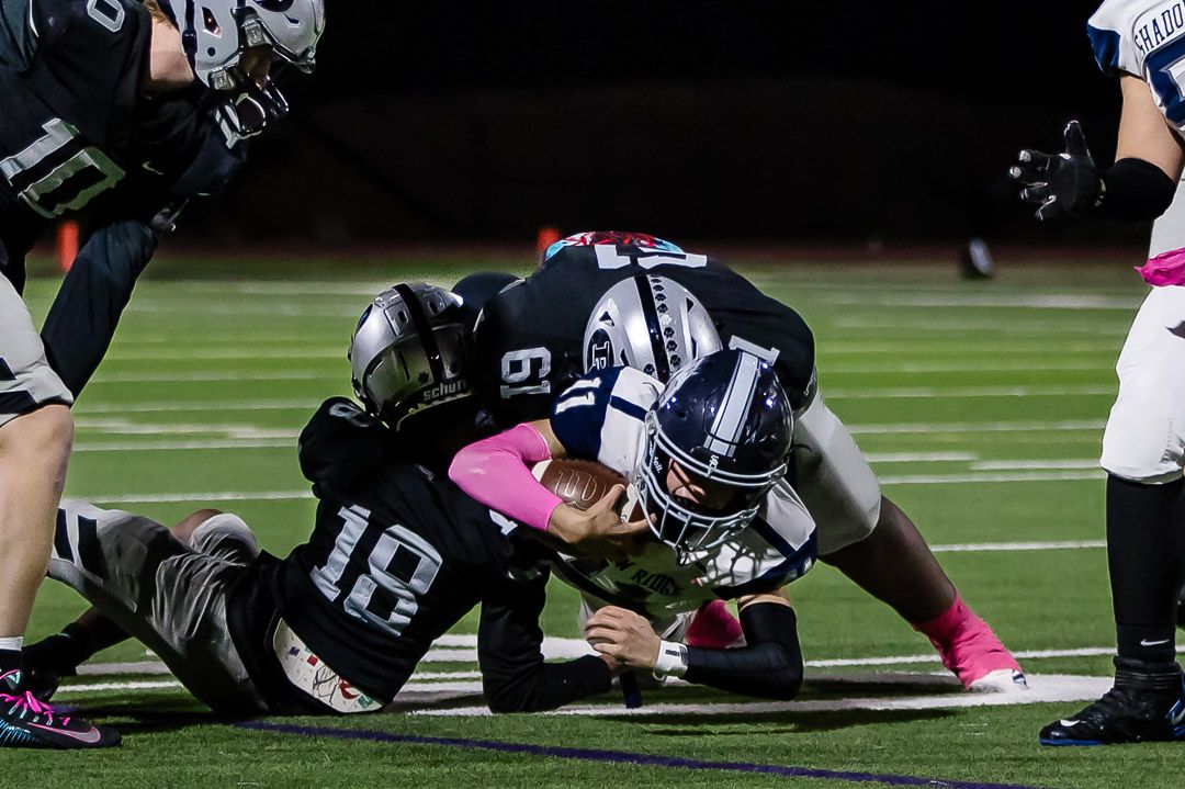 Football players clash at the line of scrimmage during a play.